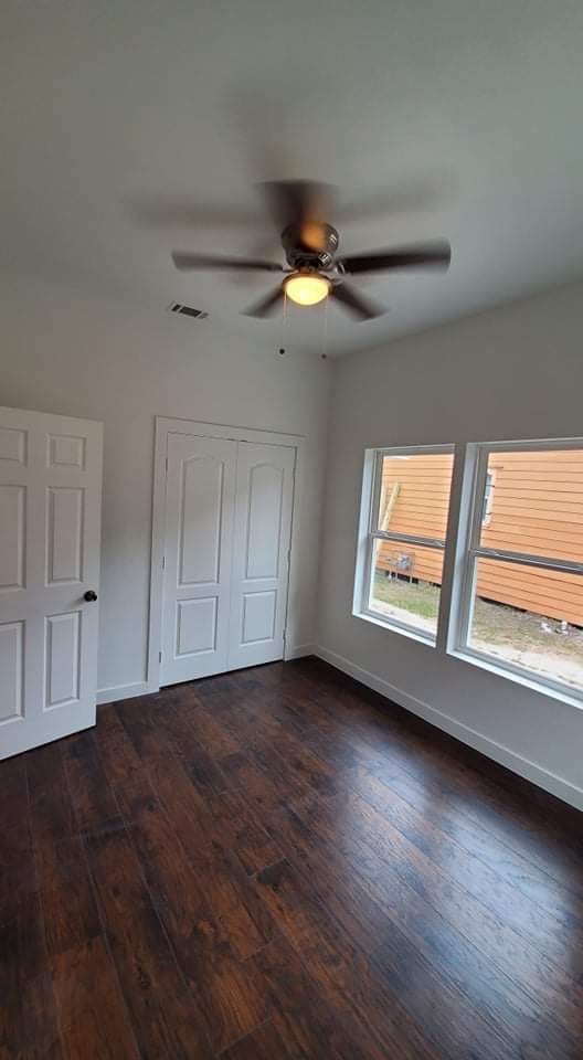 unfurnished bedroom featuring a closet, ceiling fan, and dark hardwood / wood-style floors