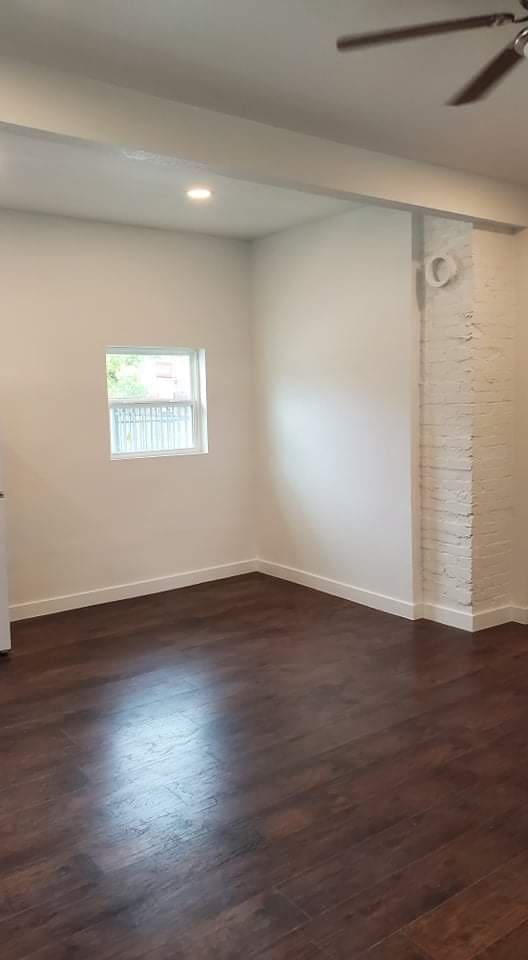 empty room with ceiling fan and dark hardwood / wood-style floors