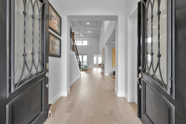 foyer featuring light hardwood / wood-style floors, beamed ceiling, and coffered ceiling