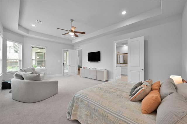 bedroom with light carpet, visible vents, baseboards, a tray ceiling, and recessed lighting