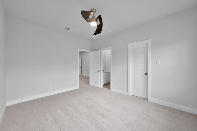 unfurnished bedroom featuring connected bathroom, carpet flooring, visible vents, and baseboards