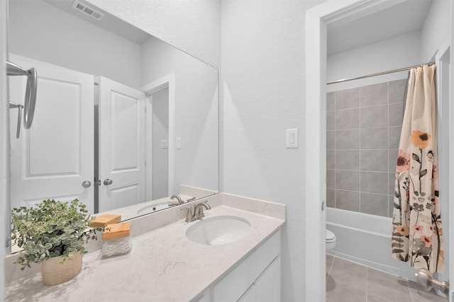 bathroom featuring toilet, vanity, visible vents, tile patterned floors, and shower / bath combo