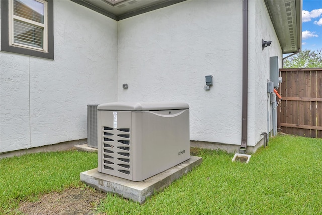 details featuring cooling unit, fence, a power unit, and stucco siding