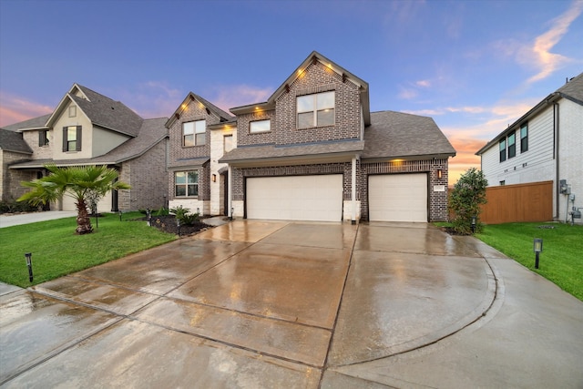 view of front of home with a garage and a lawn