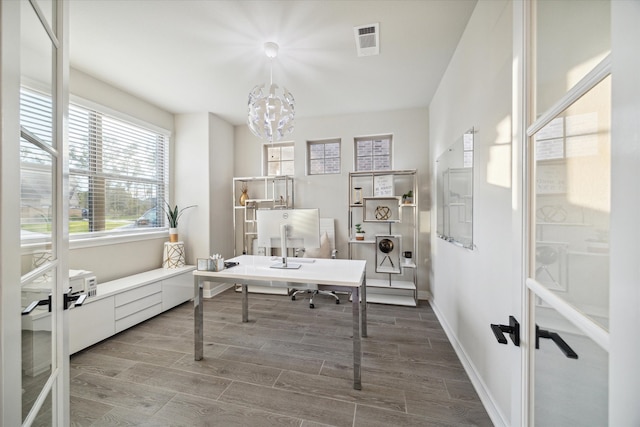 office with wood-type flooring and an inviting chandelier