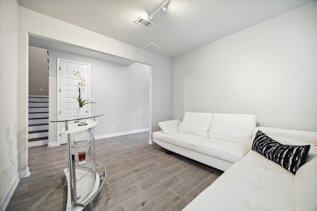 living room with track lighting and wood-type flooring