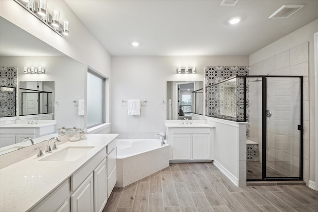 bathroom with vanity, separate shower and tub, and hardwood / wood-style floors