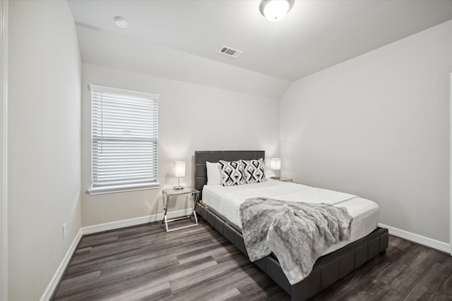 bedroom featuring dark hardwood / wood-style flooring and lofted ceiling