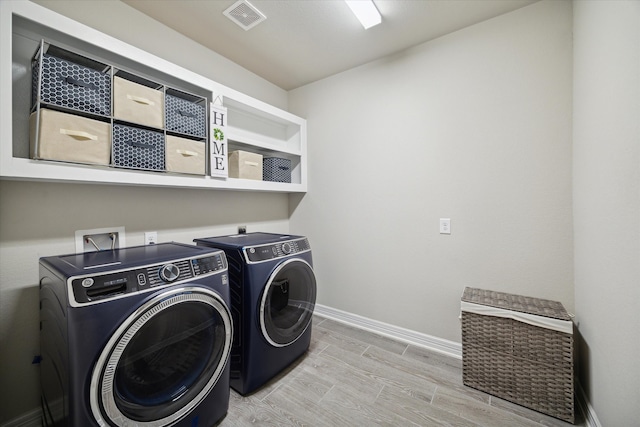 laundry area with wood-type flooring and washing machine and dryer