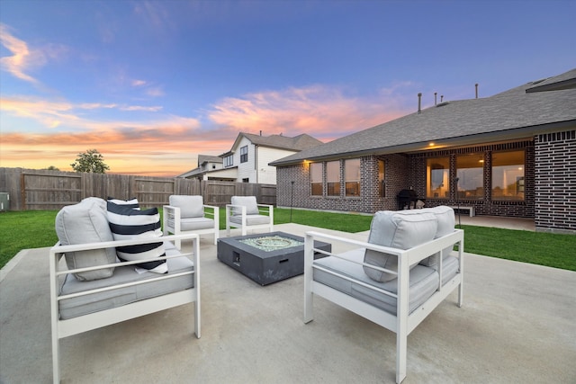 patio terrace at dusk with an outdoor living space with a fire pit