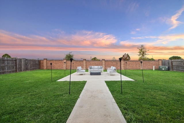 yard at dusk featuring outdoor lounge area and a patio area