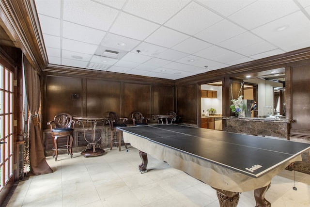 playroom featuring a paneled ceiling, wooden walls, and ornamental molding