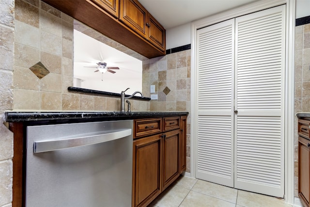 kitchen with ceiling fan, light tile patterned flooring, tile walls, and stainless steel dishwasher