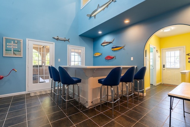 22921 Chiquita St, Galveston, TX 77554 - bar with a wealth of natural light, arched walkways, a dry bar, and tile patterned flooring