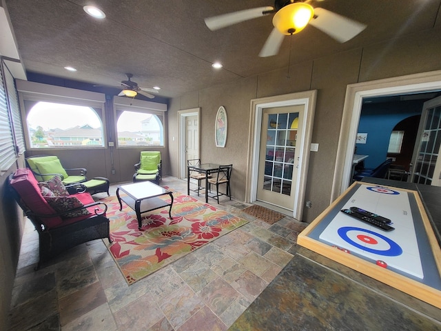 interior space featuring ceiling fan and a textured ceiling