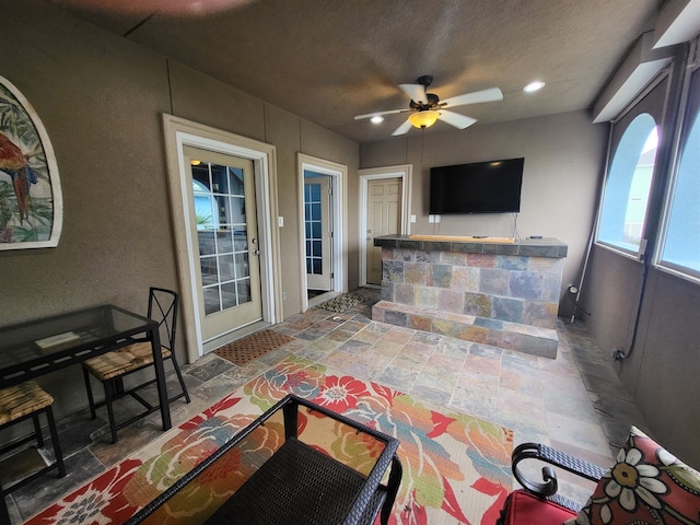 living room with a textured ceiling and ceiling fan