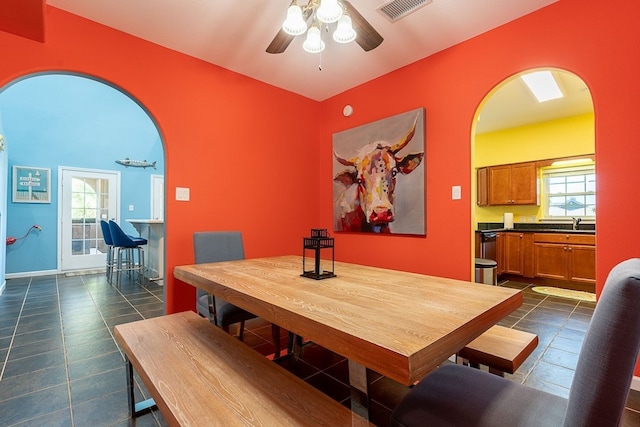 22921 Chiquita St, Galveston, TX 77554 - dining area featuring visible vents, dark tile patterned flooring, a ceiling fan, arched walkways, and baseboards
