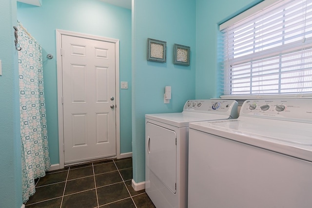 washroom featuring washing machine and dryer and dark tile patterned floors