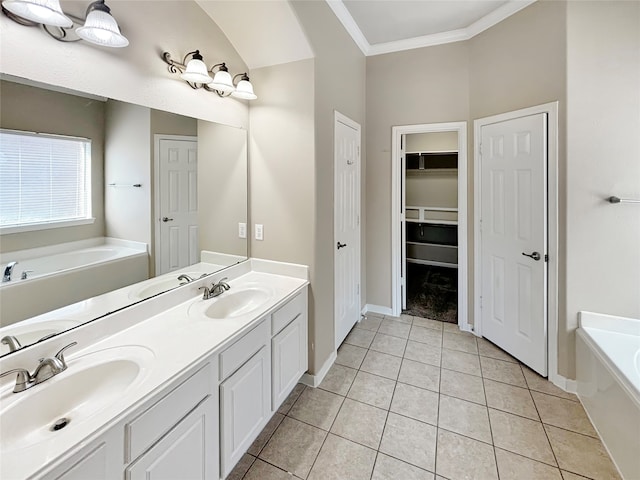 bathroom featuring tile patterned floors, a washtub, crown molding, and vanity