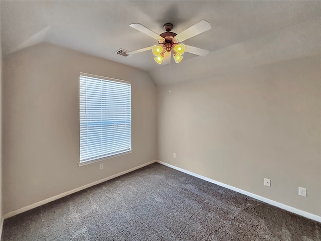 carpeted empty room with ceiling fan, a wealth of natural light, and vaulted ceiling