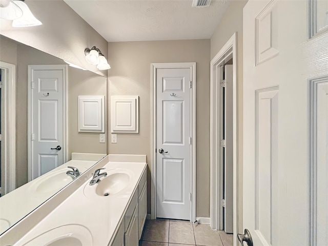 bathroom with vanity, a textured ceiling, and tile patterned floors