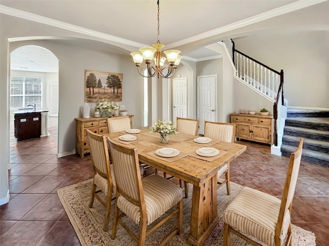 dining room featuring tile patterned flooring, an inviting chandelier, and ornamental molding