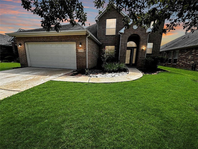 view of front facade with a yard and a garage