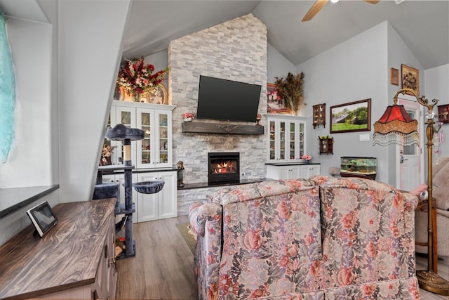 living room with lofted ceiling, ceiling fan, hardwood / wood-style flooring, and a fireplace