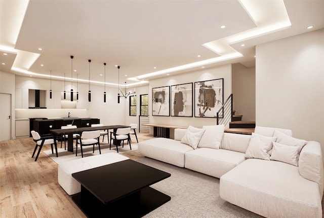 living room with a tray ceiling and light hardwood / wood-style flooring