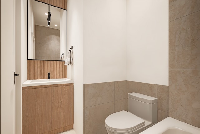 bathroom featuring a washtub, tile walls, vanity, and toilet