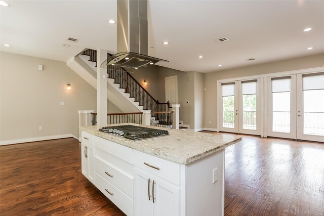 kitchen with stainless steel gas stovetop, light stone counters, white cabinetry, dark hardwood / wood-style floors, and island range hood