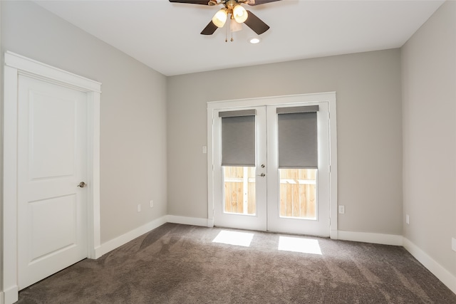 empty room featuring french doors, dark colored carpet, and ceiling fan