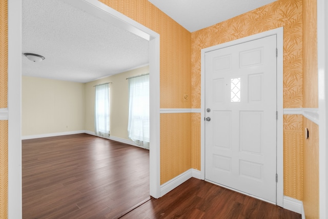 entrance foyer with a textured ceiling and dark hardwood / wood-style flooring