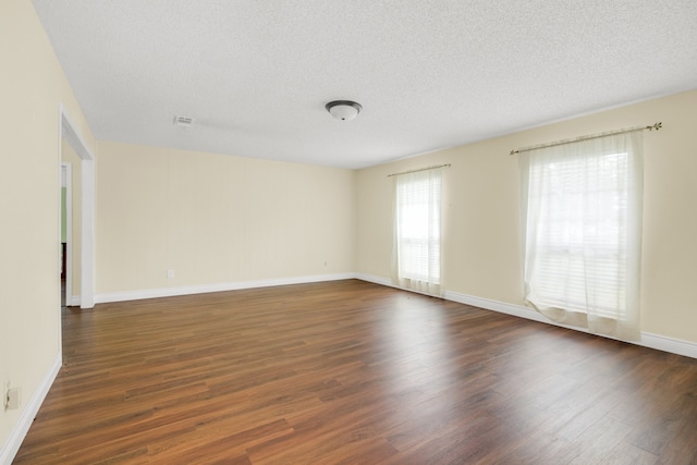 spare room with dark hardwood / wood-style flooring and a textured ceiling