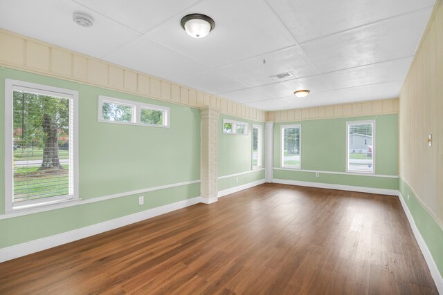 spare room featuring a wealth of natural light and dark hardwood / wood-style flooring