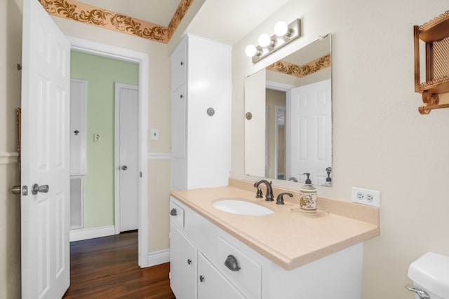 bathroom featuring vanity, toilet, and hardwood / wood-style floors