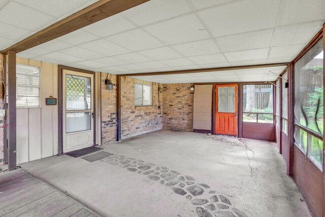 unfurnished sunroom featuring plenty of natural light and a paneled ceiling