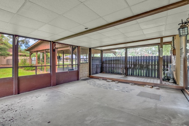 unfurnished sunroom with a paneled ceiling and a healthy amount of sunlight