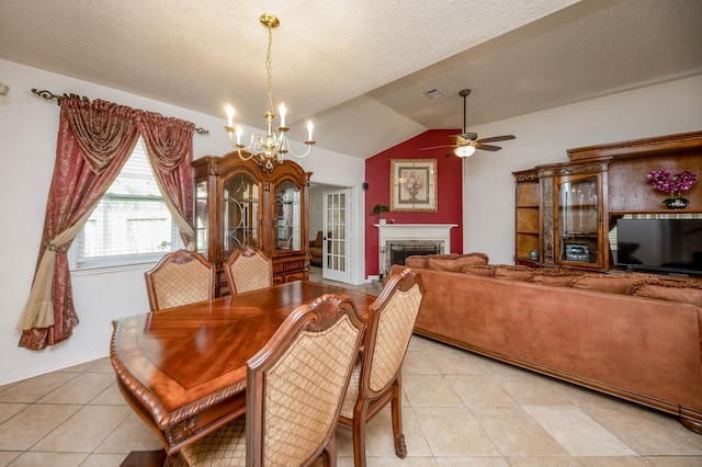 tiled dining room with lofted ceiling, ceiling fan with notable chandelier, and a textured ceiling