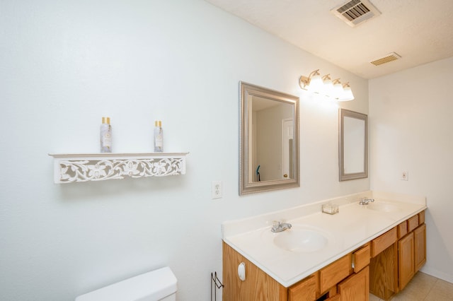 bathroom with vanity, toilet, and tile patterned flooring