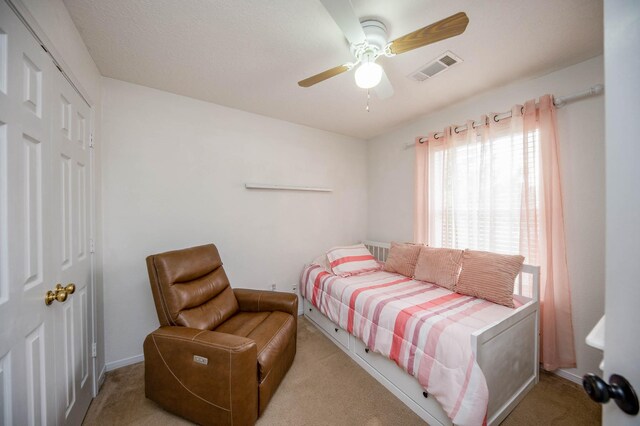 bedroom featuring a closet, ceiling fan, and light carpet