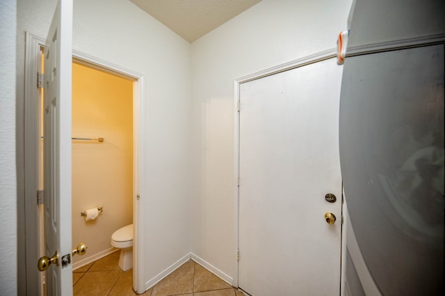 bathroom with toilet and tile patterned floors