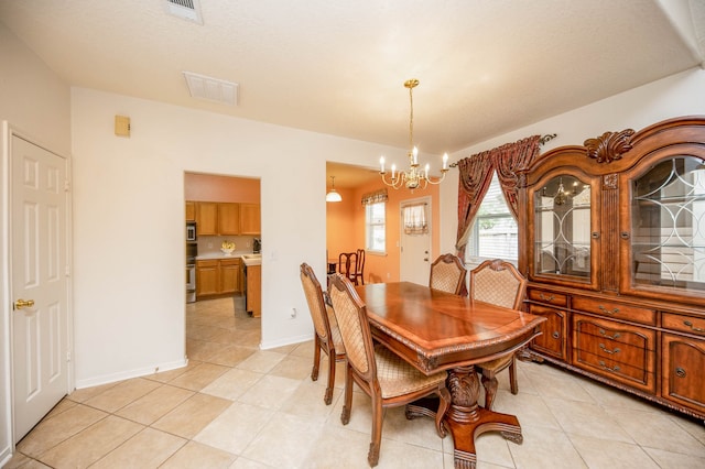 tiled dining area featuring a chandelier