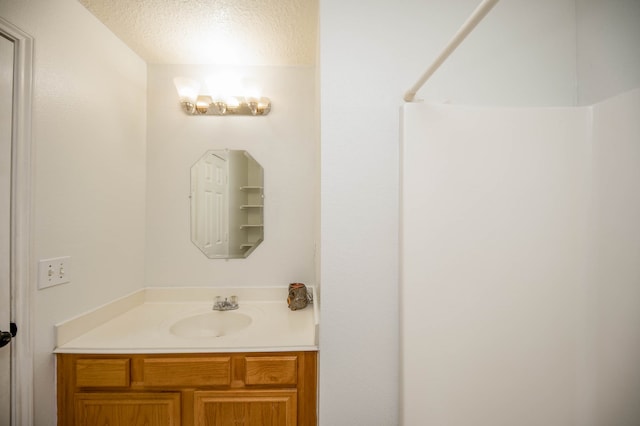 bathroom with a textured ceiling and vanity