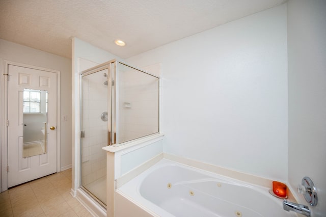 bathroom with a textured ceiling and shower with separate bathtub