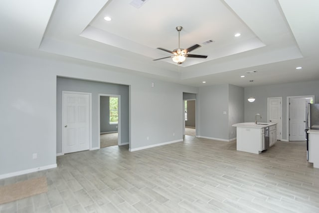 1022 Adams St, Cleveland, TX 77327 - unfurnished living room with a tray ceiling, ceiling fan, a sink, baseboards, and recessed lighting
