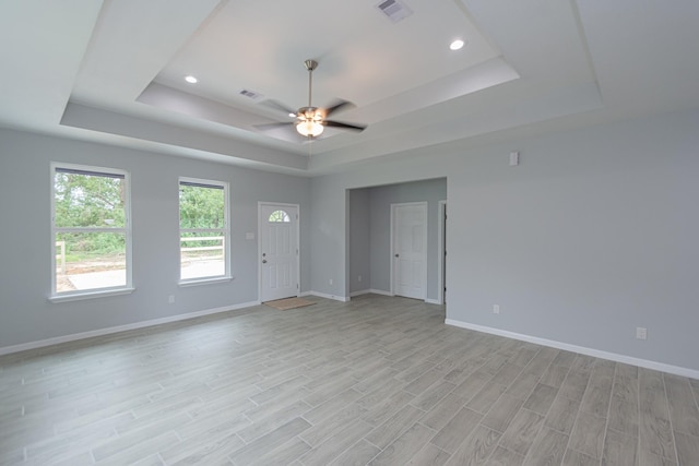 1022 Adams St, Cleveland, TX 77327 - unfurnished living room featuring a tray ceiling, a ceiling fan, baseboards, light wood-style flooring, and recessed lighting