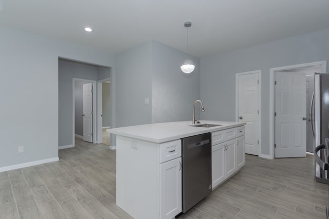 kitchen featuring white cabinets, a kitchen island with sink, sink, pendant lighting, and stainless steel appliances