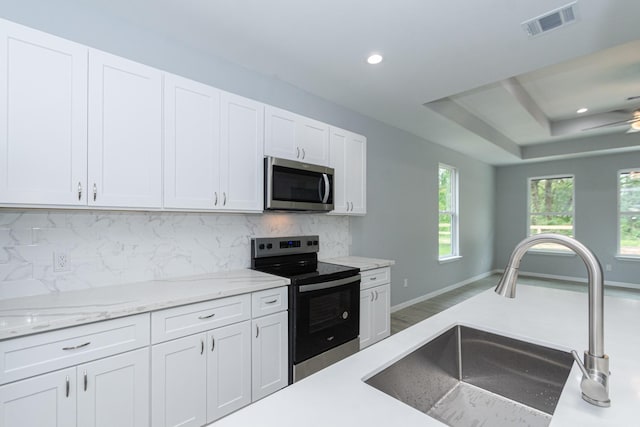 1022 Adams St, Cleveland, TX 77327 - kitchen with stainless steel appliances, a sink, white cabinetry, tasteful backsplash, and recessed lighting