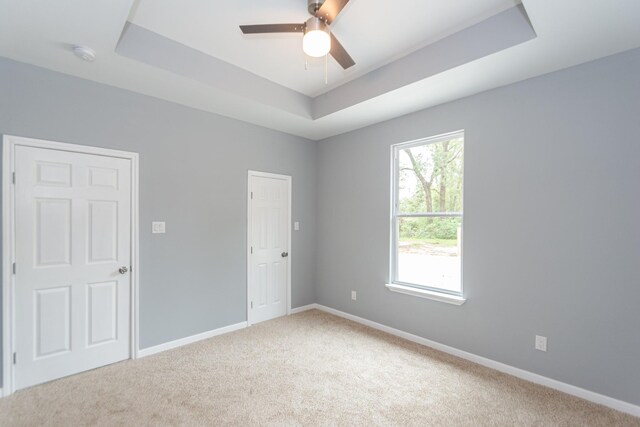 1022 Adams St, Cleveland, TX 77327 - empty room with a tray ceiling, light colored carpet, a ceiling fan, and baseboards